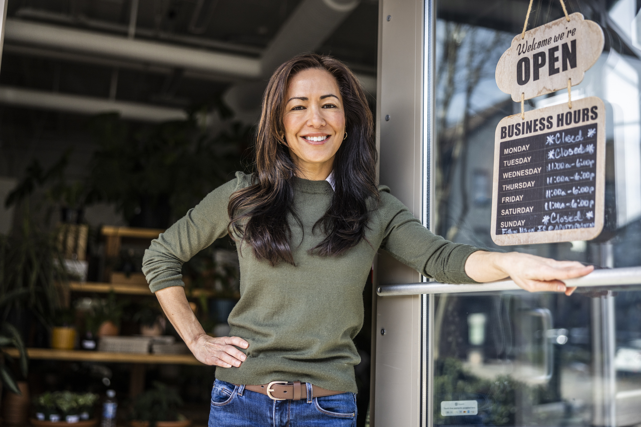 Young woman business owner standing in front of her store