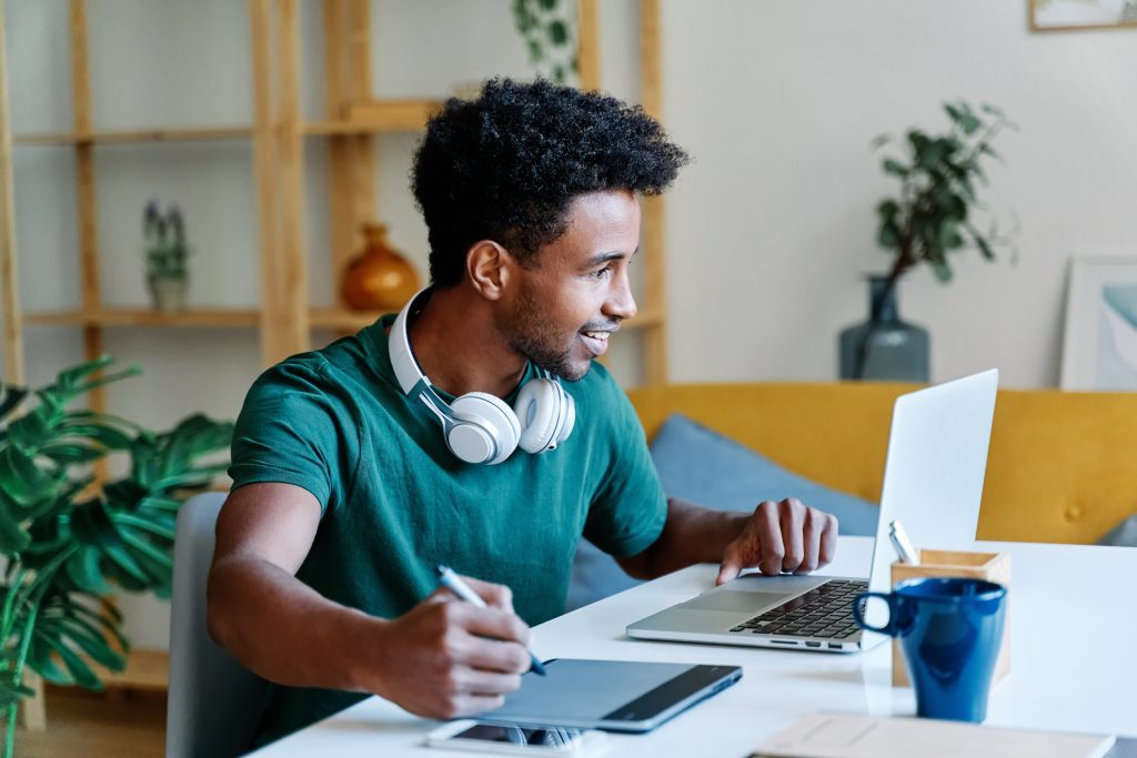 Young man who's a freelance web designer working on site